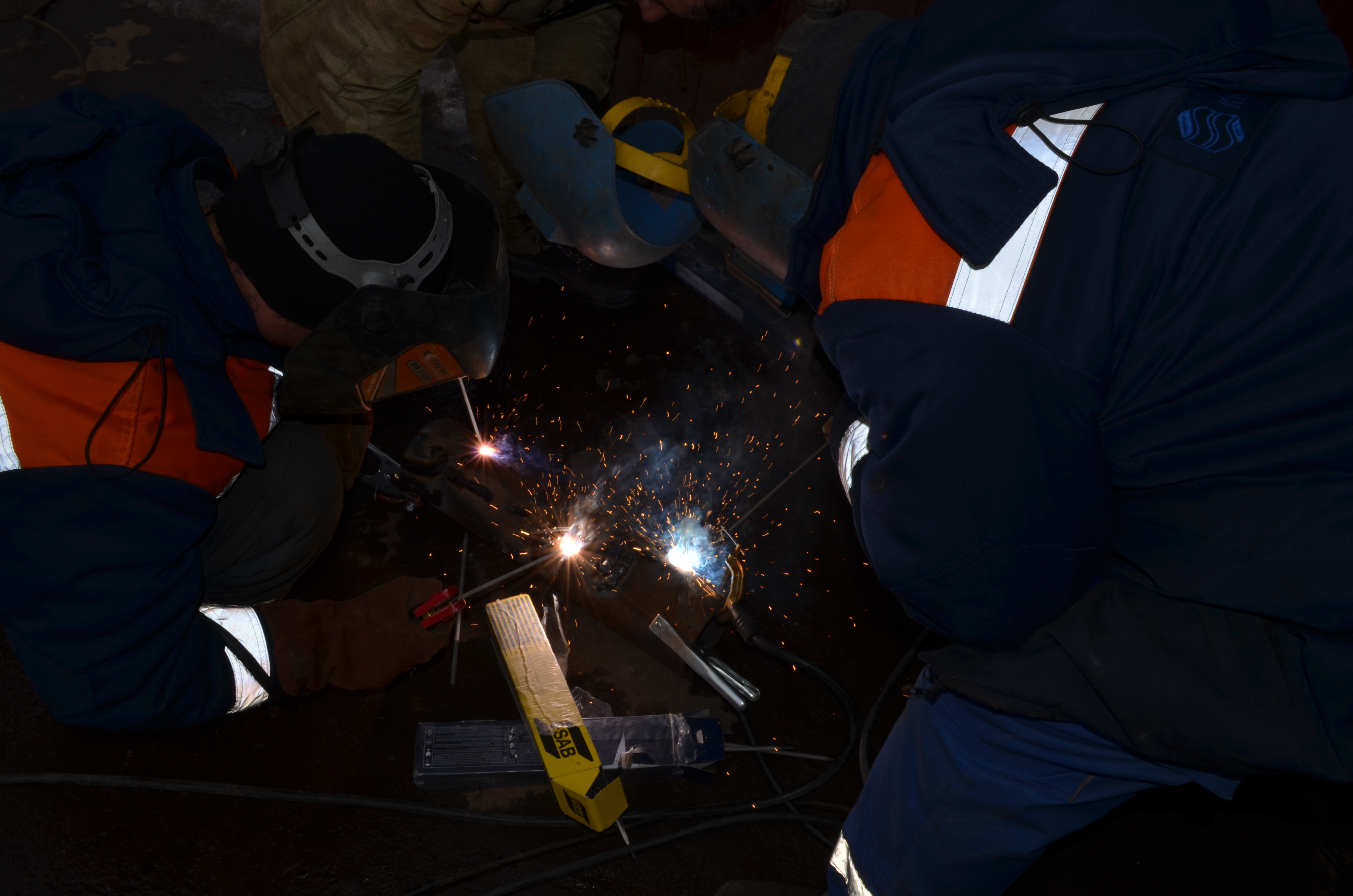 Two workers using a dual welding system